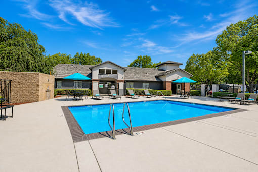 A large swimming pool in front of a house.