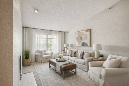 A living room with a white couch, a coffee table, and a painting on the wall.