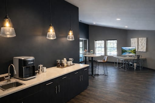 A kitchen with a black wall and a white counter top.