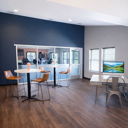 A room with a fitness area and a work area with a computer.