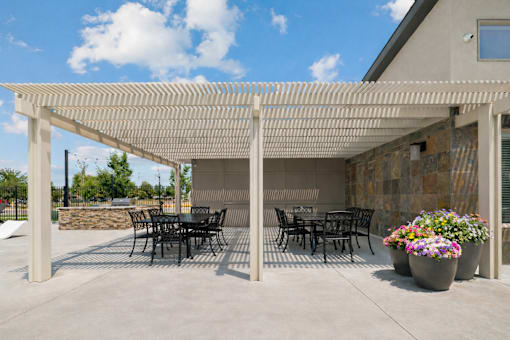 Outdoor patio with pergola and dining tables at Harper Ridge Apartments, Idaho, 83642