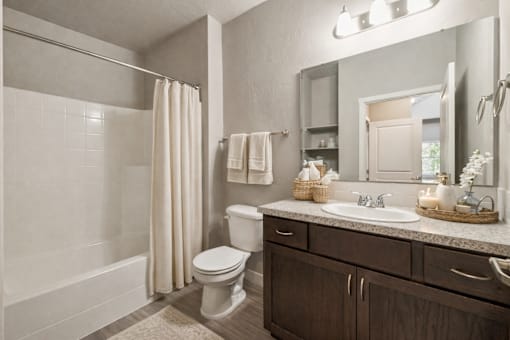 Bathroom with white tub and dark vanity at Harper Ridge Apartments, Meridian