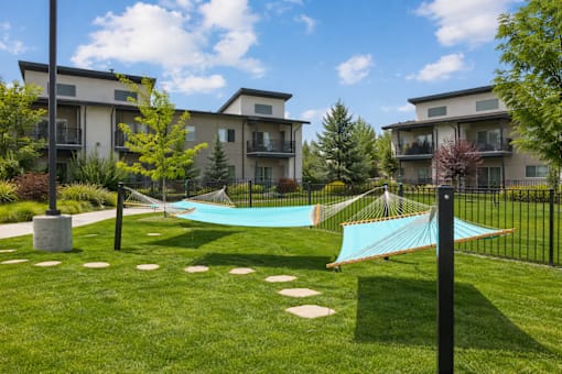 Community hammocks on manicured lawn with stepping stones at Harper Ridge Apartments, Idaho