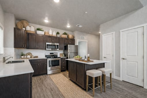 Kitchen with white countertops and island seating at Harper Ridge Apartments, Meridian, ID 83642