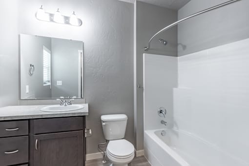 A white bathroom with a toilet, sink, and bathtub.