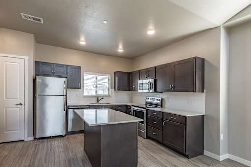 A kitchen with dark wood cabinets and stainless steel appliances.