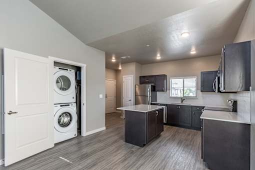 A modern laundry room with a washer and dryer built into the cabinetry.