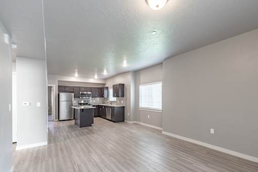 A spacious kitchen with a refrigerator, sink, and stove.
