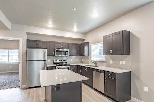 A modern kitchen with stainless steel appliances and dark wood cabinets.