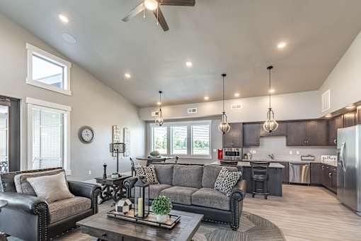 A modern living room with a grey couch and a wooden coffee table.