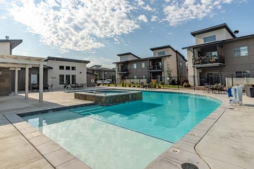 A swimming pool in front of a row of houses.