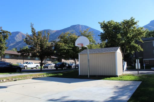 a basketball hoop in front of a building with mountains in the background