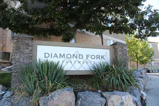 a sign in front of a building that says diamond fork apartments