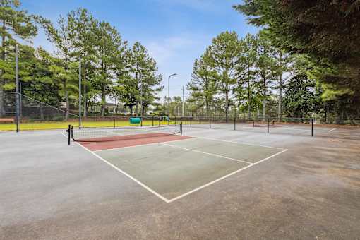 a tennis court with a red and green court in a park