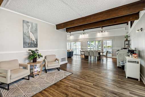 the living room and dining area of a home with a wood floor and white walls
