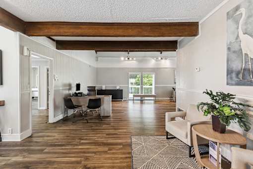 the living room and dining room of a home with wood floors and white walls