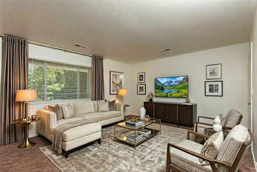 A living room with a couch, chair, and television.
