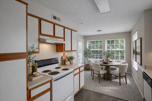 A kitchen with a dining table and chairs.