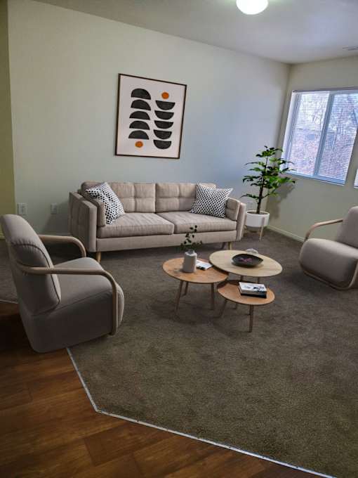 A living room with a grey couch, two grey armchairs, and a coffee table.