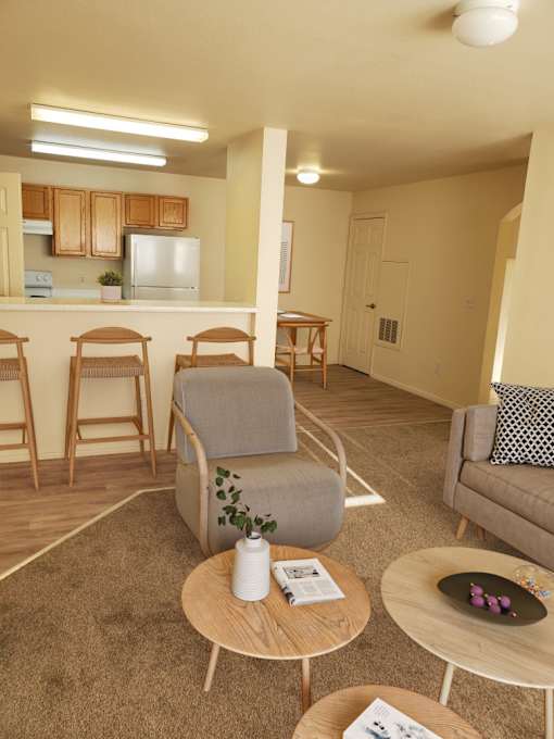 A living room with a grey couch, wooden chairs, and a coffee table.