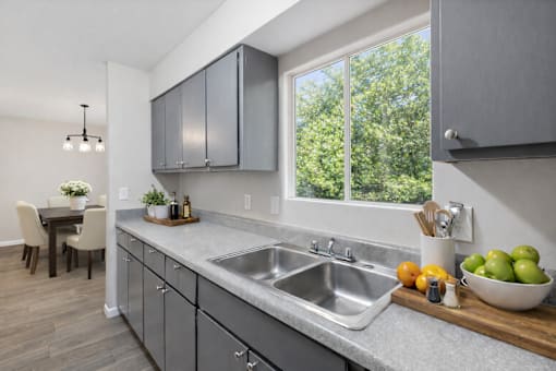 A modern kitchen with a large window and a dining table.