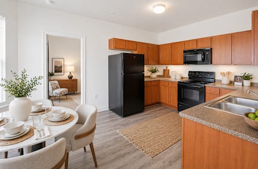 A kitchen with a black refrigerator and wooden cabinets.