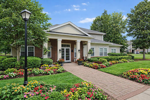 A house with a brick front porch and a brick walkway leading to it.