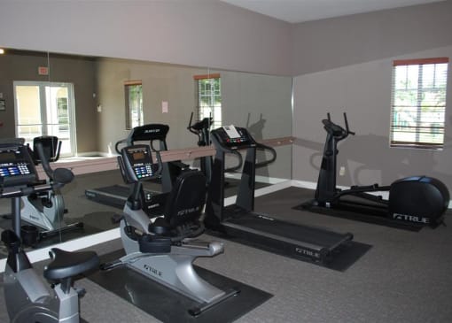 A gym with treadmills, exercise bikes, and a weight machine.