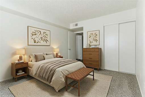 A bedroom with a bed, nightstand, and wardrobe.