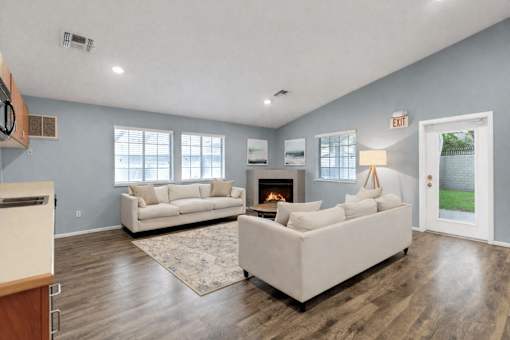 A living room with a fireplace and two couches.