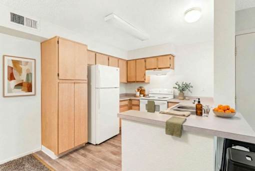 A kitchen with wooden cabinets and a white refrigerator.