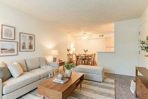 A living room with a couch, coffee table, and pictures on the wall.