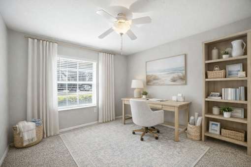 A room with a desk, chair, and a fan. at Waterbridge Apartments , Florida