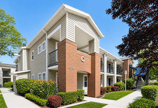 A modern two-story apartment building with a brick pillar and number 333 on it.