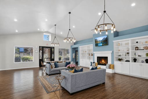 A living room with a grey couch and a fireplace.