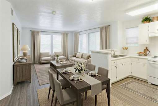 A modern kitchen and dining room with a wooden table set for two.