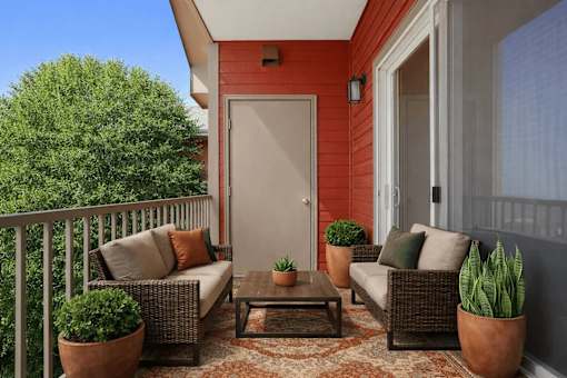 Covered balcony with wicker seating and potted plants at Stetson Meadows Apartments, Colorado