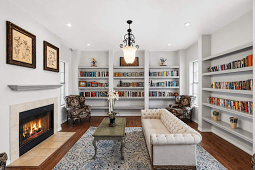 A living room with a fireplace, bookshelves, and a couch.