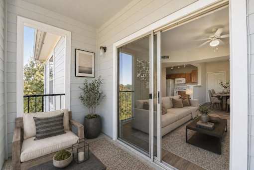 A balcony with a chair and a potted plant.