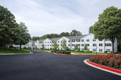 A white building with a black driveway in front.