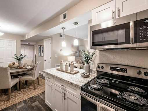 A modern kitchen with a black stove top oven and a black microwave above the counter.
