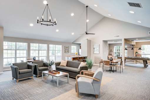 A spacious living room with a variety of seating options and a large window.
