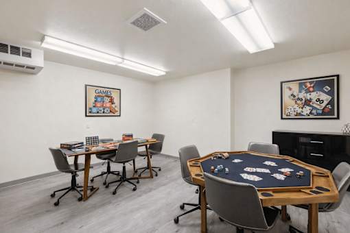 A room with a poker table and chairs.