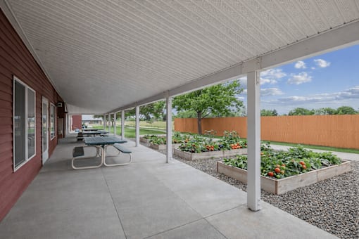 A patio with a table and chairs is covered by a white roof.