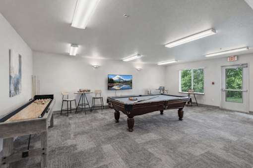 A room with a pool table, a billiard table, and a TV.