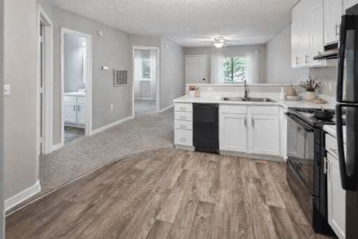 Open kitchen with white cabinetry and black appliances at Davidson Homes Apartments, Concord