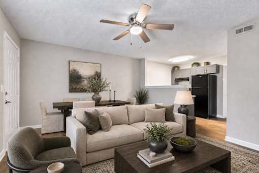 A living room with a couch, chair, and a ceiling fan.