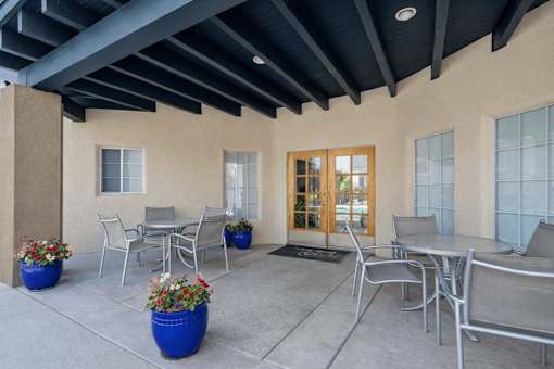 Covered patio with outdoor dining furniture at Vista Linda Apartments, New Mexico