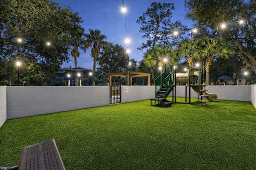 A park with a bench and a playground. at Epic Apartments , Daytona Beach, Florida