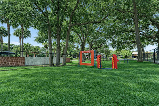 A playground with a red slide and a red climbing frame. at Epic Apartments , Florida